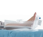 Side view of a calf and foot, supported on a Repose Foot Protector Plus. the label and valve are seen at the base of the foot.  The leg and foot look like they are floating off the bed.