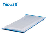 Repose Mattress Overlay lying flat without a cover, with a blue base and clear top, with the air cells of Repose running along the length of the overlay.